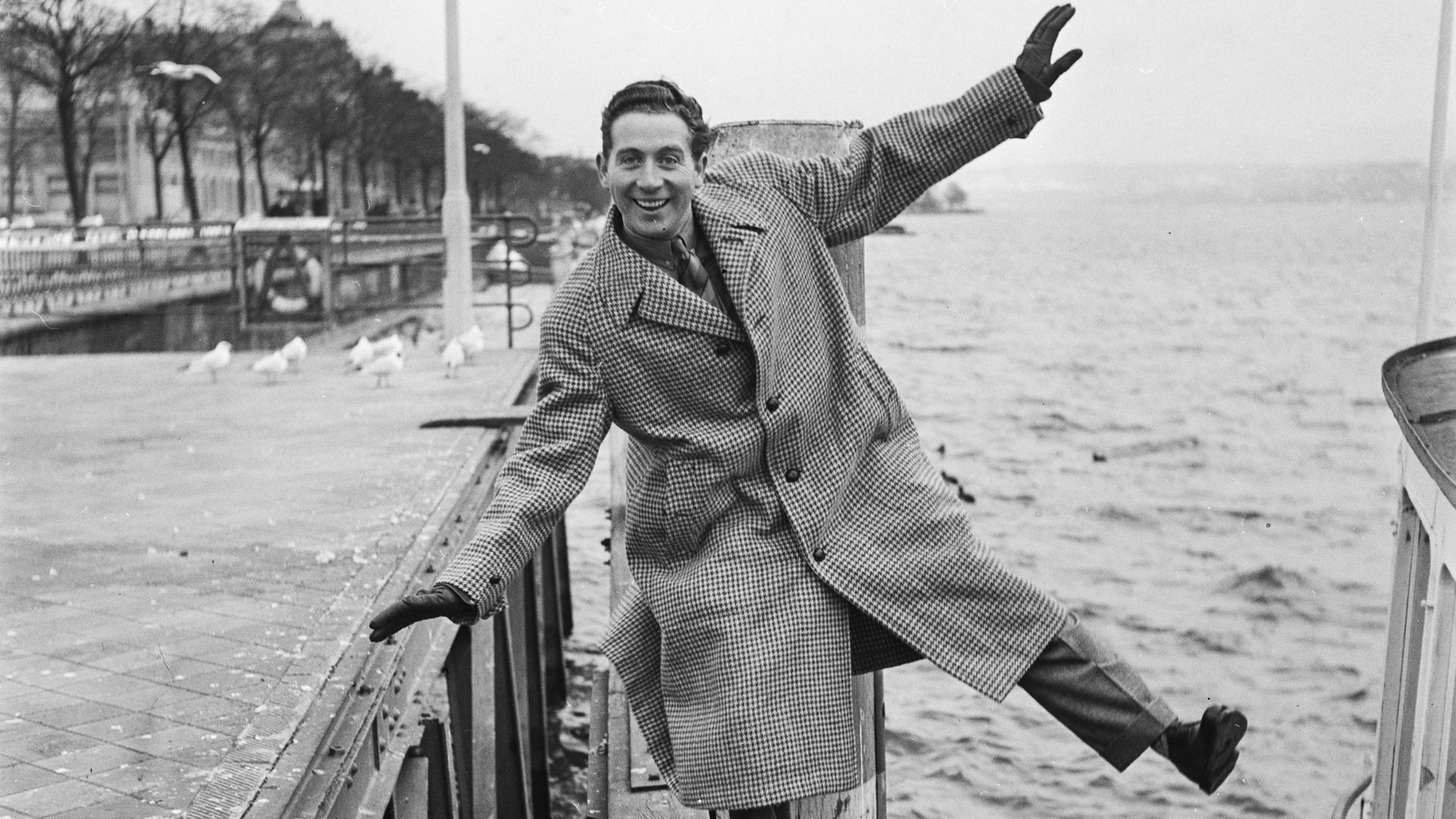 Charles Trenet posiert mit von sich gestreckten Armen und Beinen auf einem Bootssteg. Charles Trenet posiert mit von sich gestreckten Armen und Beinen auf einem Bootssteg.