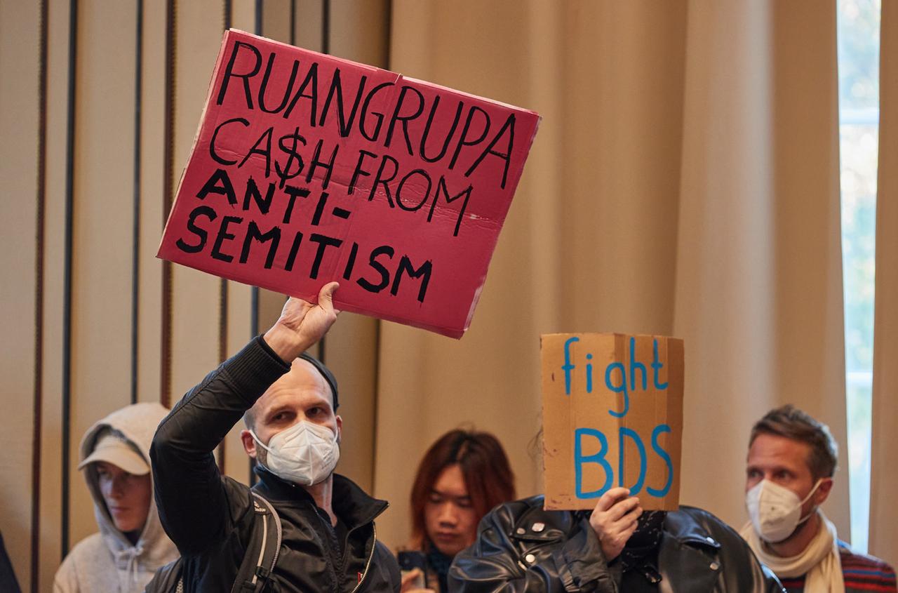 Protestierende halten in der Aula der Hochschule für bildende Künste Hamburg (HfbK) Transparente mit der Aufschrift "Ruangrupa C$sh From Antisemitism" und "Fight BDS" hoch. Protestierende halten in der Aula der Hochschule für bildende Künste Hamburg (HfbK) Transparente mit der Aufschrift "Ruangrupa C$sh From Antisemitism" und "Fight BDS" hoch.