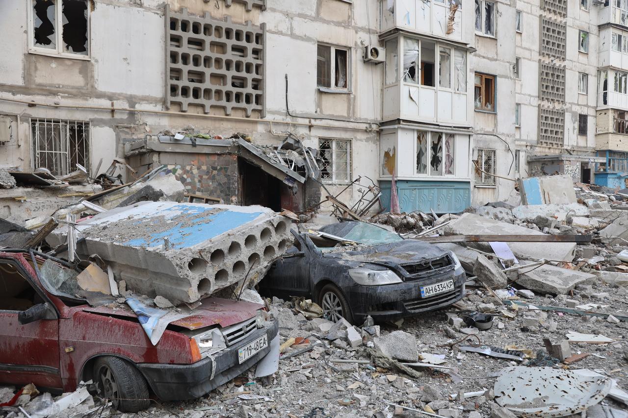 Zerstörte Häuserblock und Autos unter Trümmern in Mariupol nach einem Beschuss russischer Truppen 