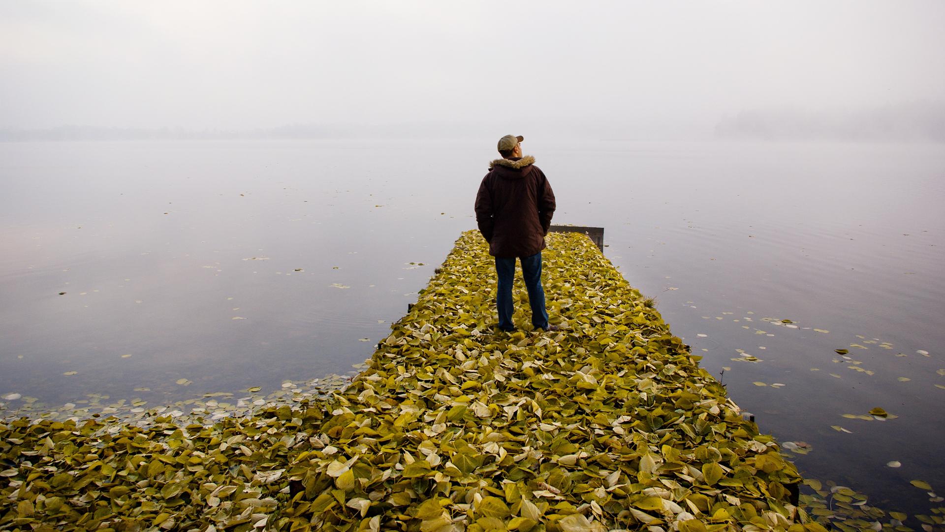 Ein Mann lässt seinen Blick über den See schweifen.