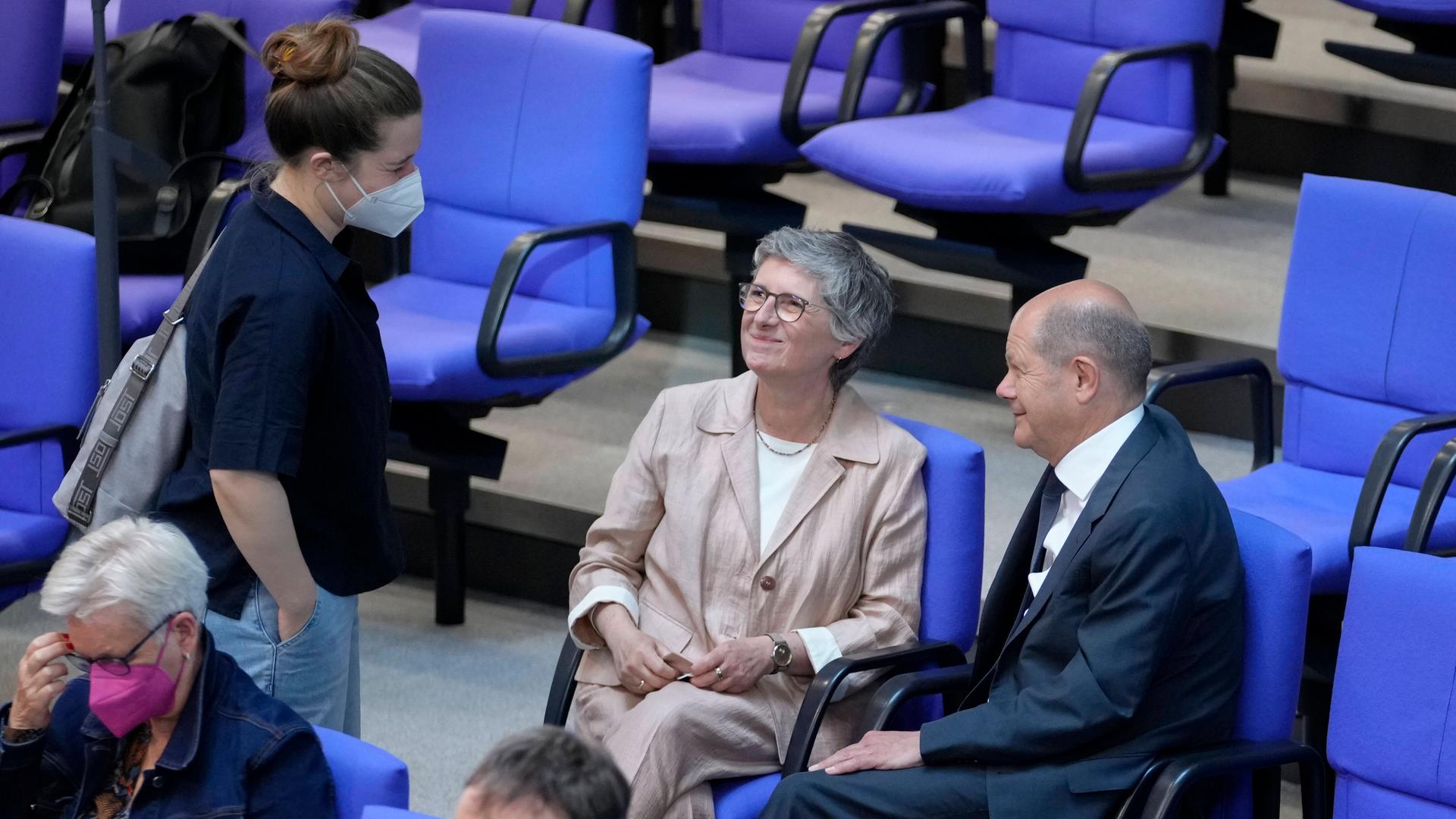 Aufnahme aus dem Bundestag. Darauf zu sehen, der sitzende Bundeskanzler Olaf Scholz, rechts neben ihm Britta Hasselmann. Vor den beiden steht die jungen Abgeordneten Emilia Fester. Aufnahme aus dem Bundestag. Darauf zu sehen, der sitzende Bundeskanzler Olaf Scholz, rechts neben ihm Britta Hasselmann. Vor den beiden steht die jungen Abgeordneten Emilia Fester.