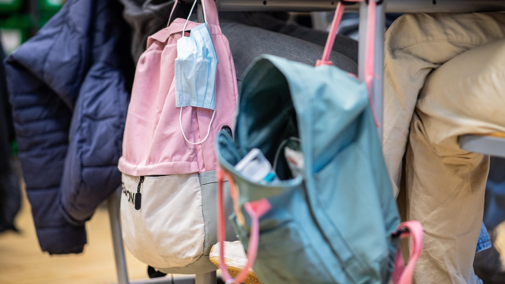 In der 9. Klasse der Gesamtschule in Münster hängt an einem Klassentisch neben einem Rucksack eine Mund- Nasenbedeckung. In der 9. Klasse der Gesamtschule in Münster hängt an einem Klassentisch neben einem Rucksack eine Mund- Nasenbedeckung.