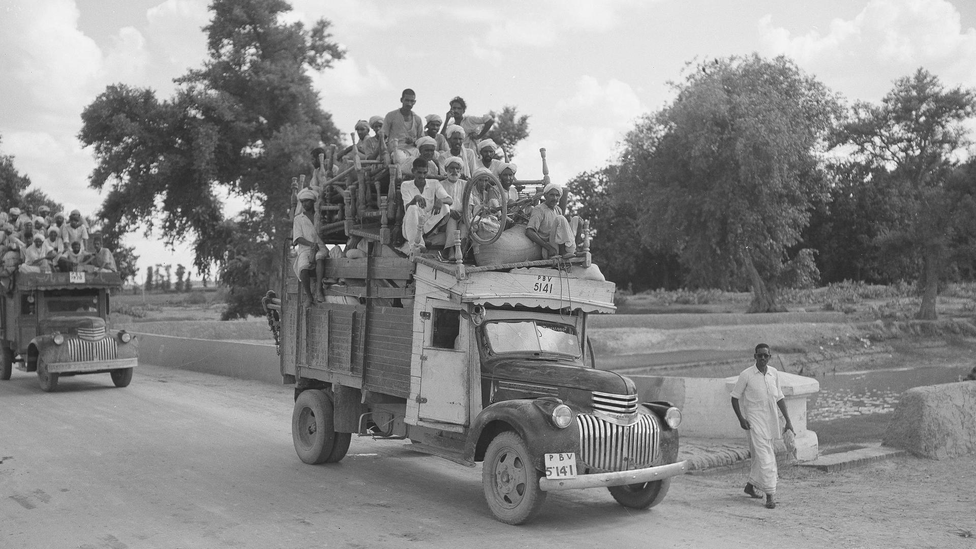 Historisches Schwarzweißfoto von 1947: Flüchtlinge sitzen auf einem mit Möbeln beladenen LKW.
