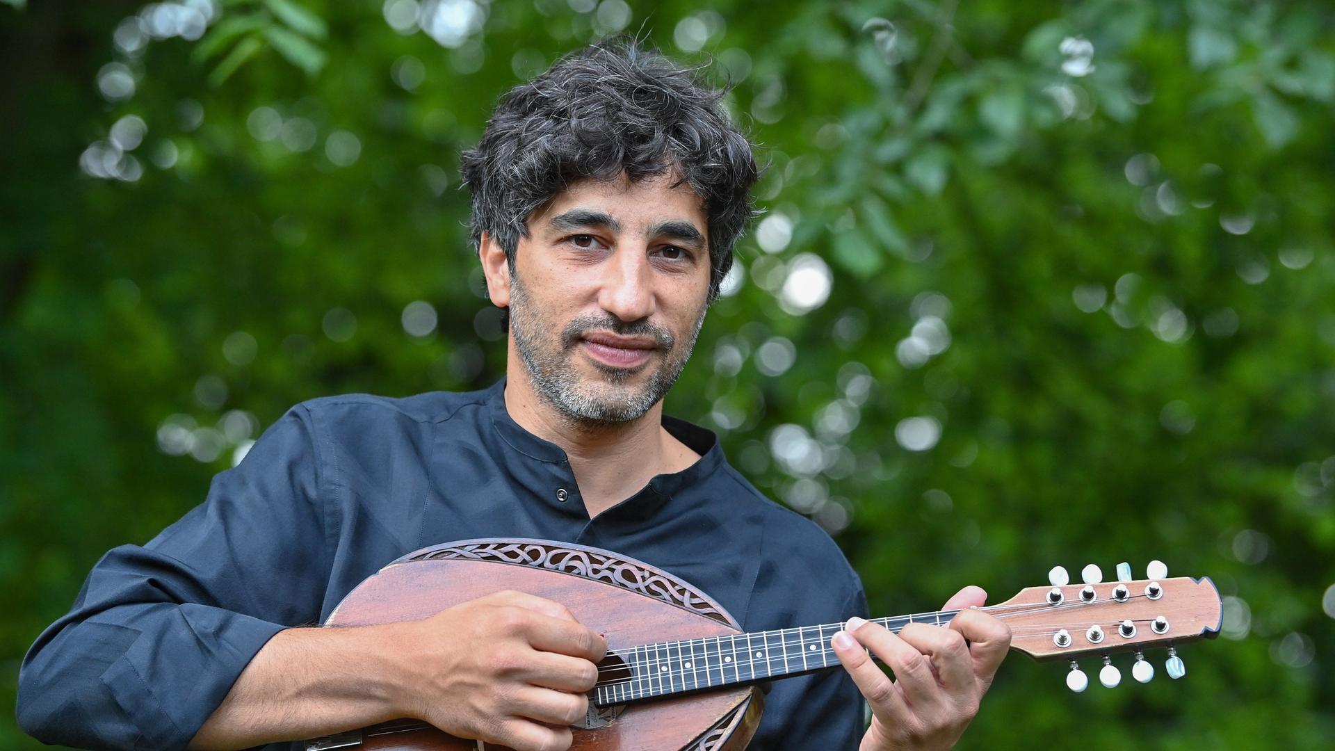Avi Avital mit einer Mandoline in Händen. Avi Avital mit einer Mandoline in Händen.