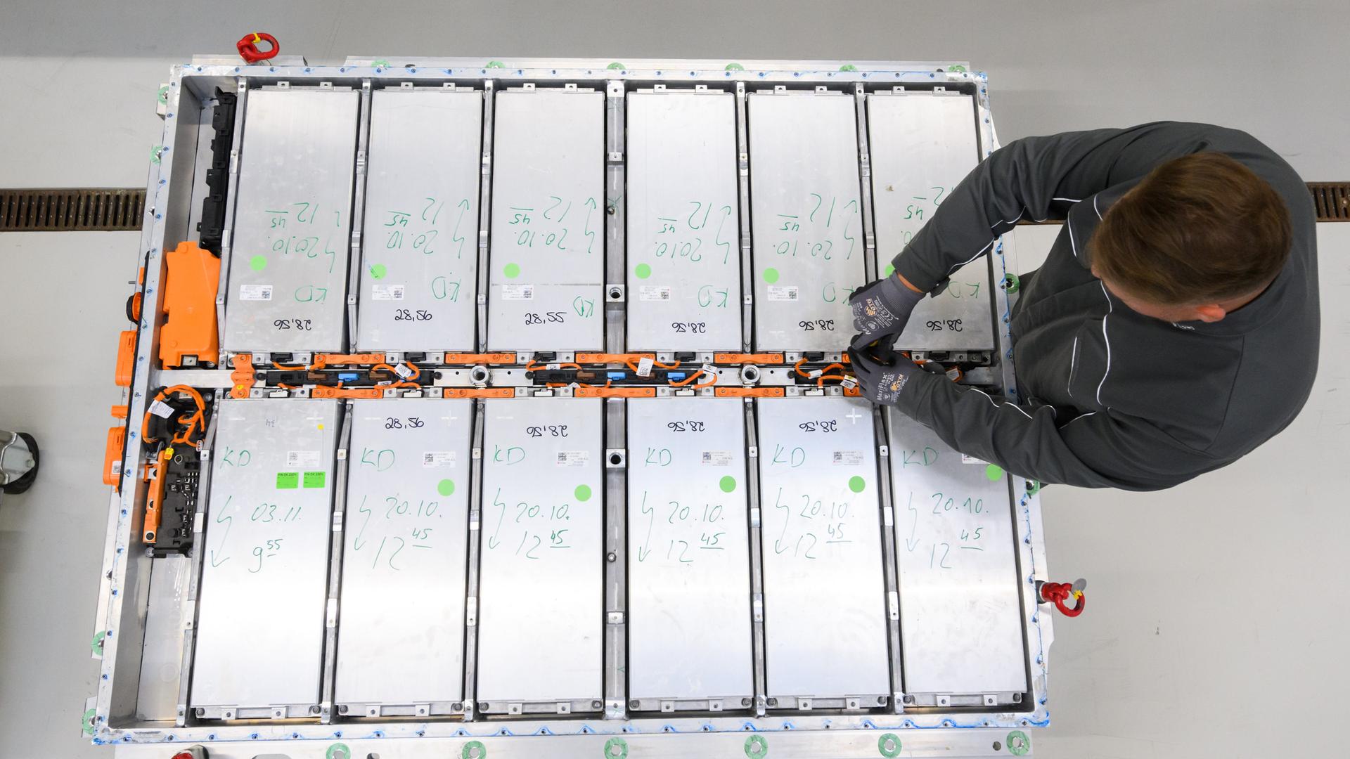 Ein Mitarbeiter entnimmt Batteriemodule aus einer ausgedienten Batterie eines Elektroautos im Batterie-Recycling des VW-Werks Salzgitter. 
