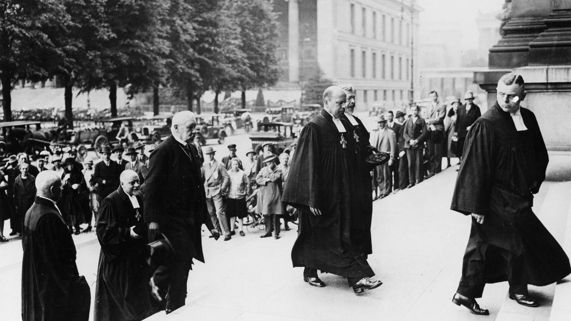 Reichspräsident Paul von Hindenburg schreitet mit evangelischen Pfarrern im Talar die Treppen zum Berliner Dom hoch. Reichspräsident Paul von Hindenburg schreitet mit evangelischen Pfarrern im Talar die Treppen zum Berliner Dom hoch.
