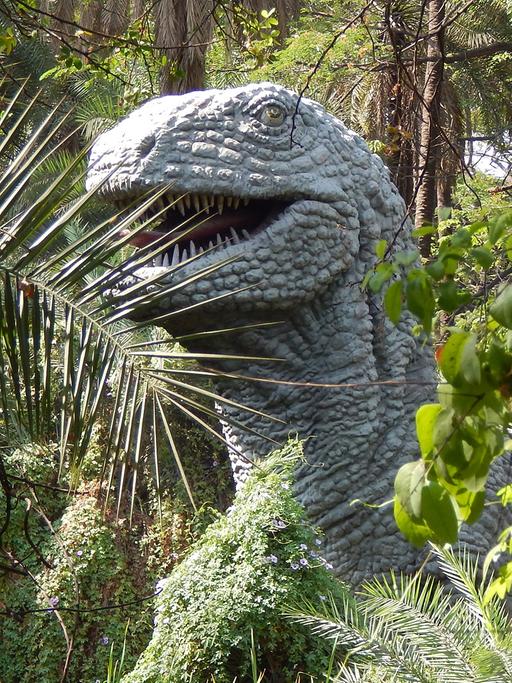 Eine Dinosaurier-Büste in einem Park. 