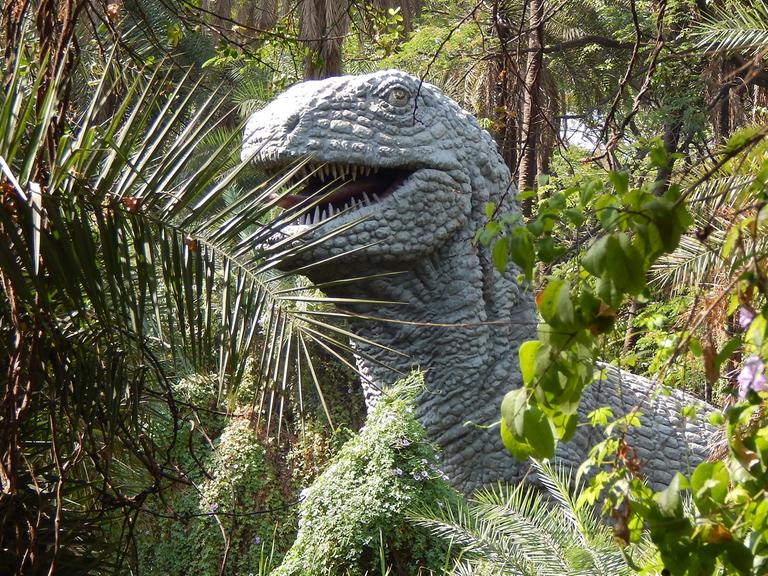 Eine Dinosaurier-Büste in einem Park. 