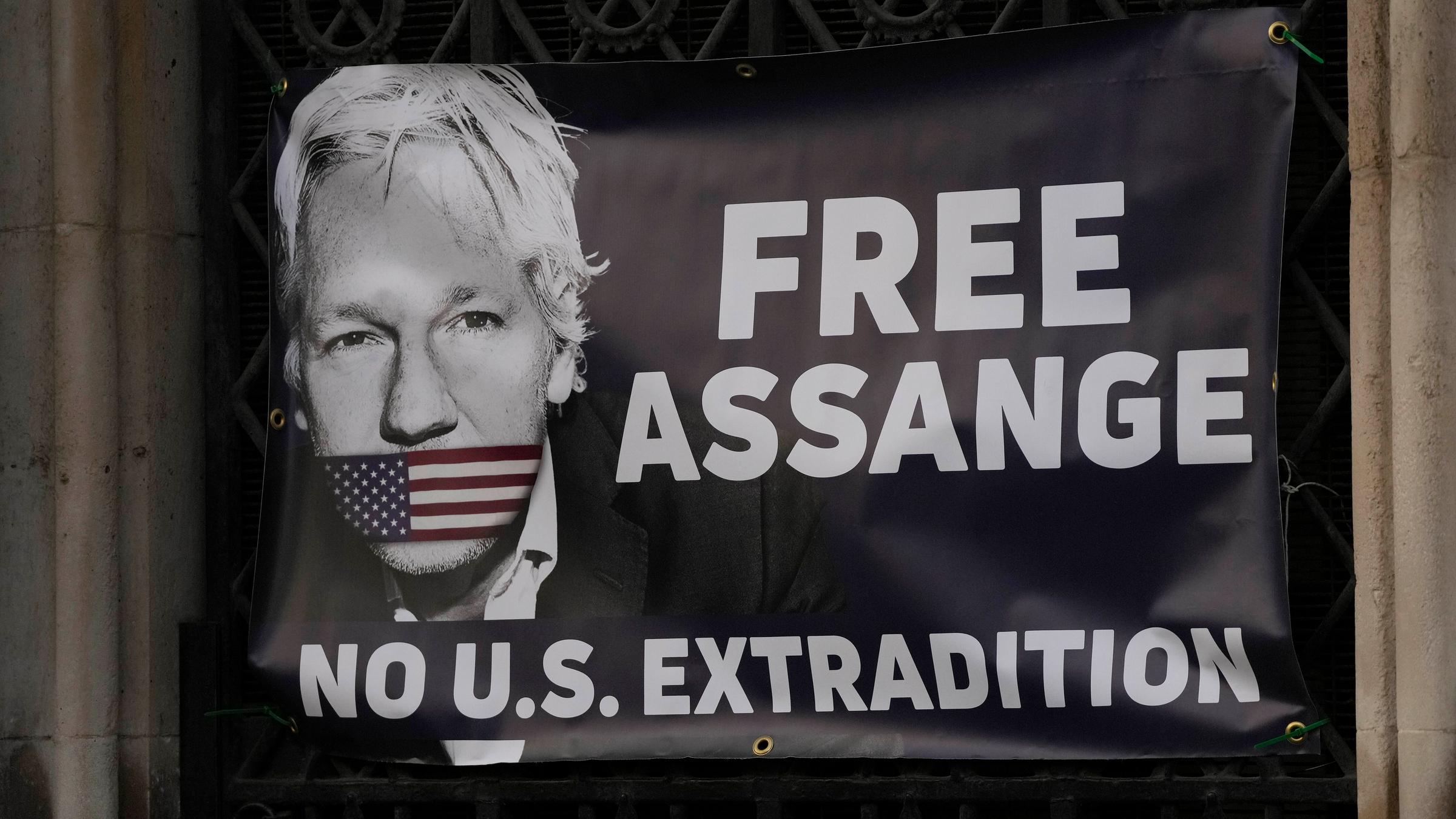 Ein Banner mit einem Foto von Julian Assange und der Aufschrift: "...</p>

                        <a href=