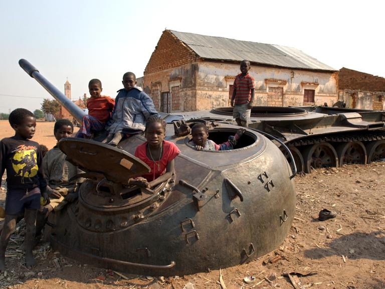 Ein auf eine Mine gefahrener Panzer dient den Kindern 2003 in dem Dörfchen Kunje nahe der völlig zerschossenen Provinzhauptstadt Kuito 2003 als Spielgerät
