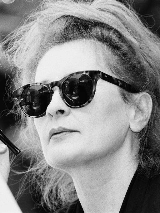 Ingrid Caven mit großer Sonnenbrille und einer Zigarette im Zigarettenhalter