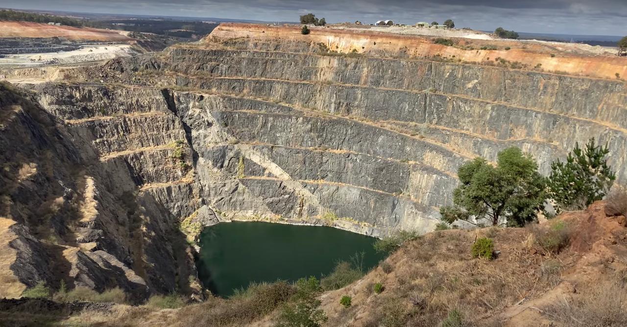 Eine riesige graue abgestufte Schlucht auf deren Boden ein kleiner See liegt. Eine riesige graue abgestufte Schlucht auf deren Boden ein kleiner See liegt.