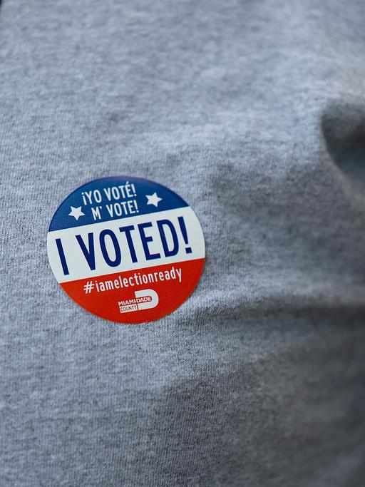 Ein Wähler trägt nach der Stimmabgabe in einem Wahllokal am 23. August 2022 in Miami, Florida, einen "Ich habe gewählt"-Aufkleber in englisch und spanisch. Bei den Vorwahlen in Florida gaben die Wähler im ganzen Bundesstaat ihre Stimmen ab.