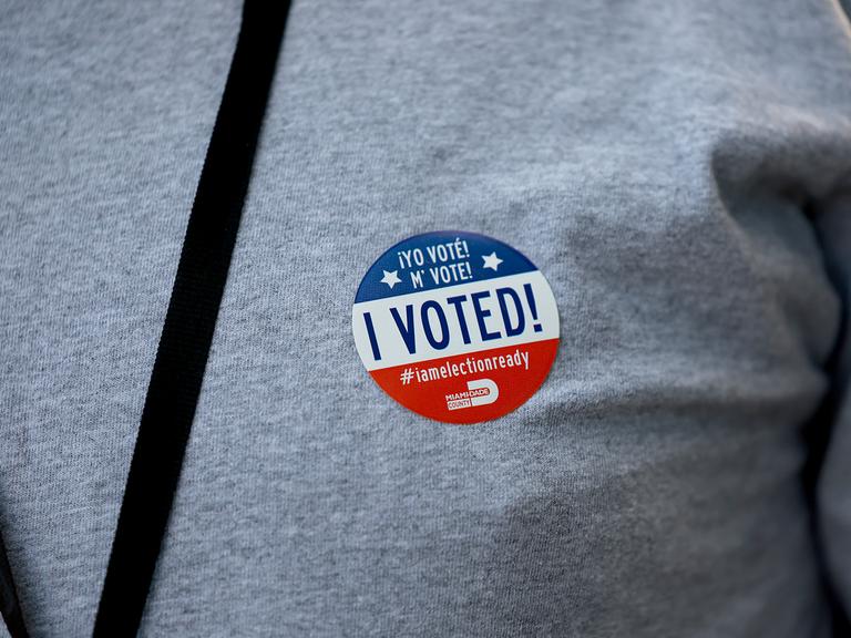 Ein Wähler trägt nach der Stimmabgabe in einem Wahllokal am 23. August 2022 in Miami, Florida, einen "Ich habe gewählt"-Aufkleber in englisch und spanisch. Bei den Vorwahlen in Florida gaben die Wähler im ganzen Bundesstaat ihre Stimmen ab.