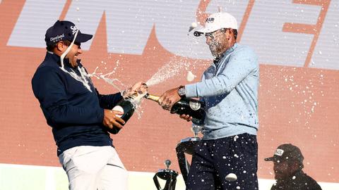 Profigolfer Charl Schwartzel und Hennie Du Plessis feiern bei der Siegerehrung der LIV Golf Invitational Series. 