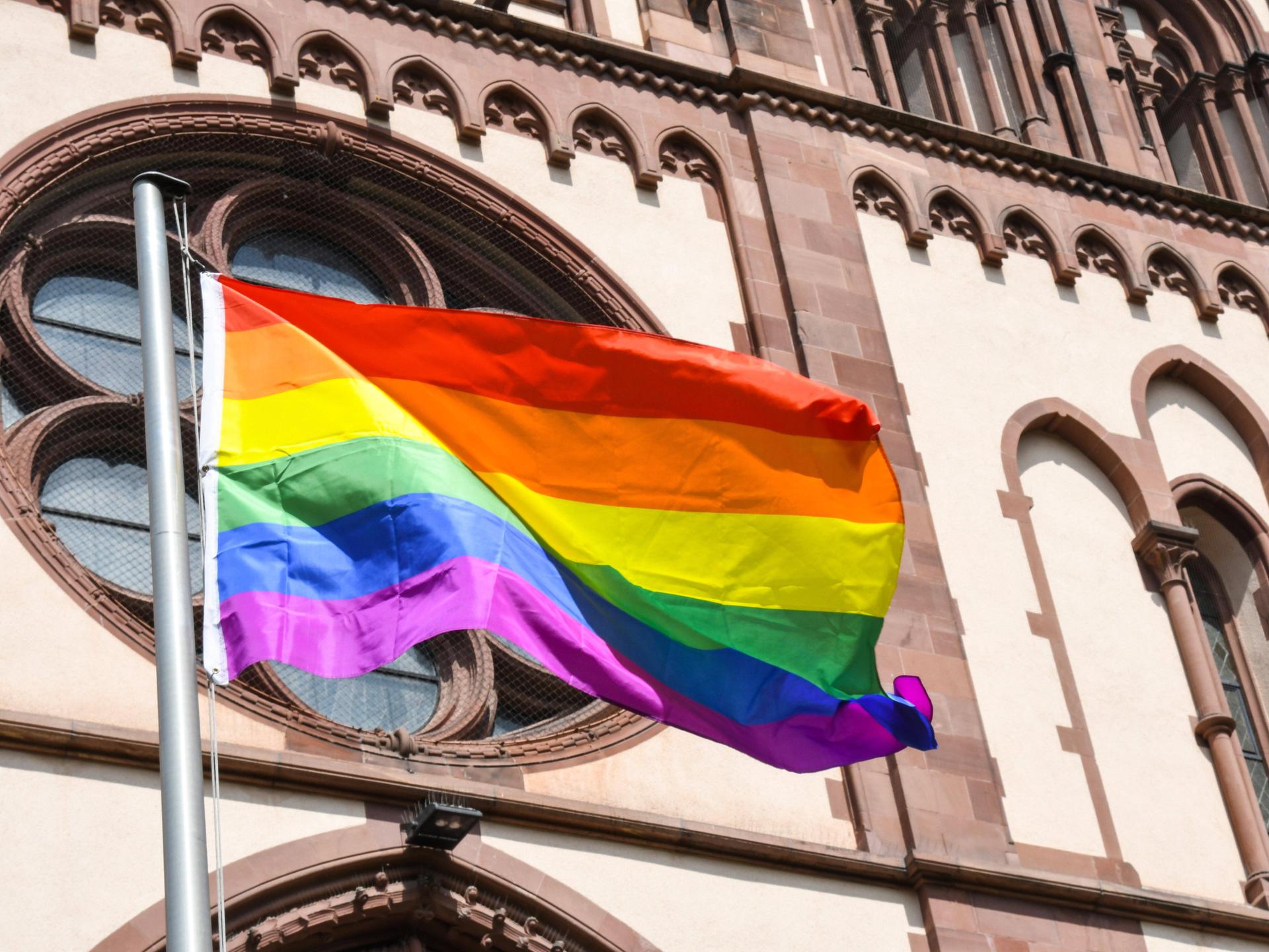 Eine Regenbogenfahne weht an der an der Herz-Jesu-Kirche in Freiburg . *** A rainbow flag flies at the Herz Jesu church in Freiburg, Germany