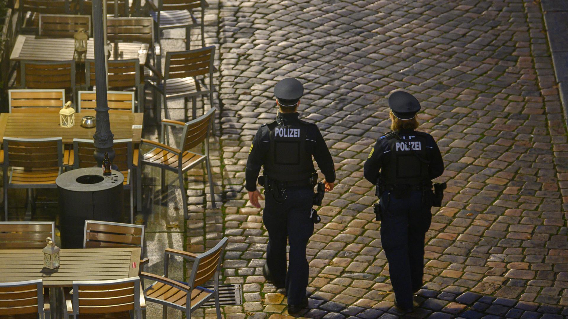 Polizisten laufen am Abend in der Dresdner Altstadt an Restaurants entlang. Die Polizeidirektion Dresden kontrolliert die Einhaltung der neuen Corona-Regeln täglich mit 50 Beamtinnen und Beamten. Im Fokus stehen demnach Kontrollen der FFP2-Maskenpflicht im öffentlichen Nahverkehr sowie die Ausgangsbeschränkungen für Ungeimpfte in Hotspot-Gebieten. Polizisten laufen am Abend in der Dresdner Altstadt an Restaurants entlang. Die Polizeidirektion Dresden kontrolliert die Einhaltung der neuen Corona-Regeln täglich mit 50 Beamtinnen und Beamten. Im Fokus stehen demnach Kontrollen der FFP2-Maskenpflicht im öffentlichen Nahverkehr sowie die Ausgangsbeschränkungen für Ungeimpfte in Hotspot-Gebieten.