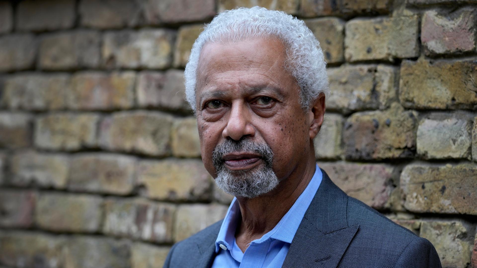 Der Nobelpreisträger Abdulrazak Gurnah steht vor einr Ziegelmauer Der Nobelpreisträger Abdulrazak Gurnah steht vor einr Ziegelmauer