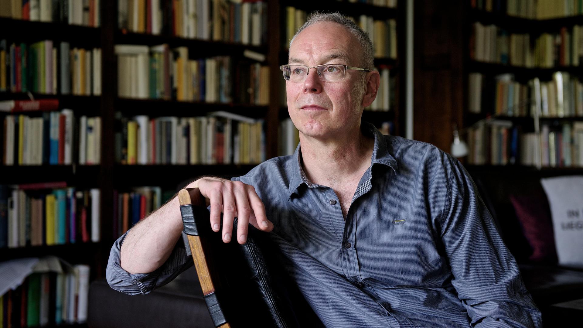 Der Autor und Journalist Günther Wessel sitzt entspannt auf einem Stuhl vor einer Bibliothek. Der Autor und Journalist Günther Wessel sitzt entspannt auf einem Stuhl vor einer Bibliothek.