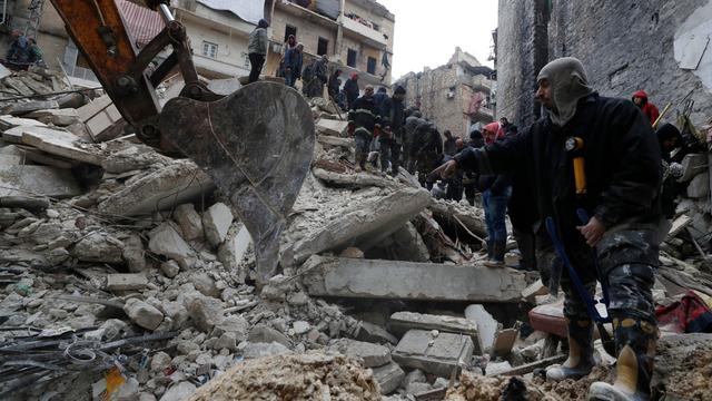 Syrien, Aleppo: Mitarbeiter des syrischen Zivilschutzes und Sicherheitskräfte durchsuchen die Trümmer eingestürzter Gebäude. In der Türkei und in Syrien sind infolge der starken Erdbeben mindestens 2.300 Menschen getötet worden.