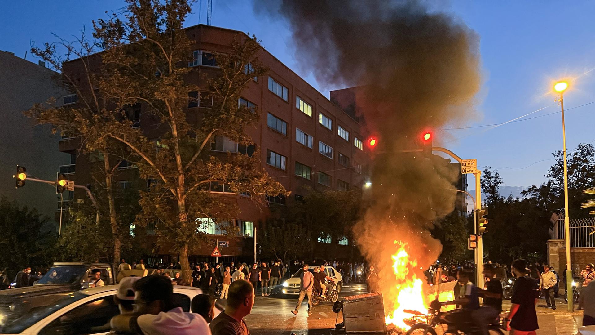 Es ist Nacht in Teheran. Auf einer Kreuzung brennt es. Es ist Nacht in Teheran. Auf einer Kreuzung brennt es.