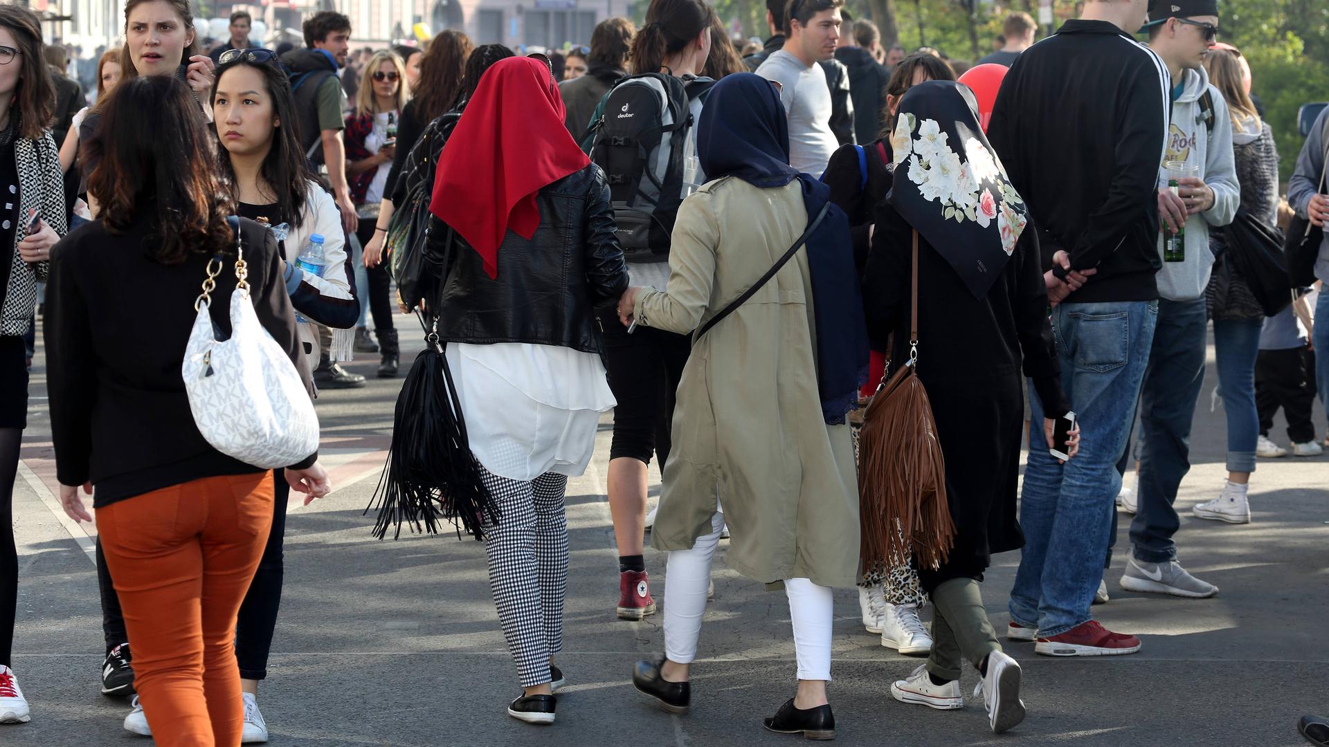 Drei junge Musliminnen mit Kopftuch beim Myfest in Berlin. Drei junge Musliminnen mit Kopftuch beim Myfest in Berlin.
