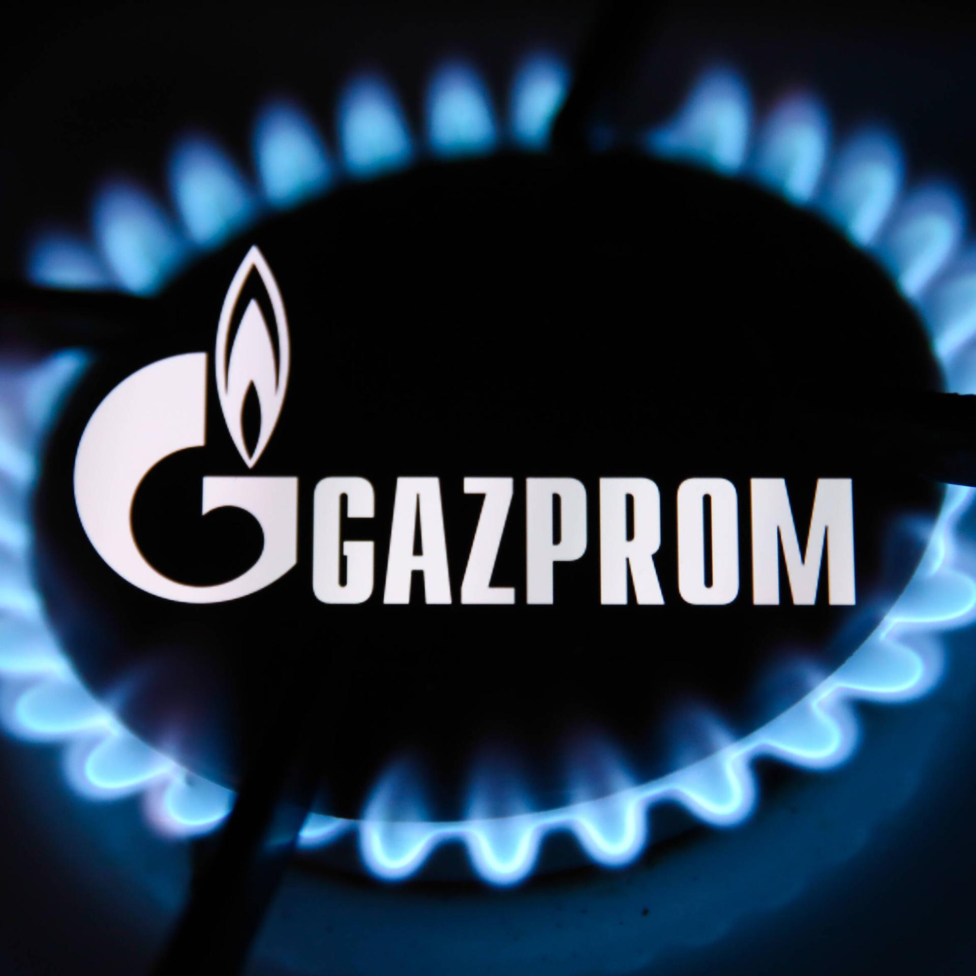 Gazprom Photo Illustrations Gazprom logo displayed on a phone screen and flames from a gas burner are seen in this multi