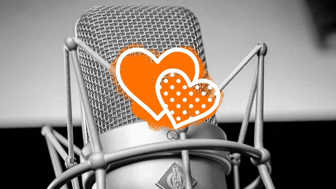 Ein altes Mikrofon mit zwei orangenen Herzen darauf. 