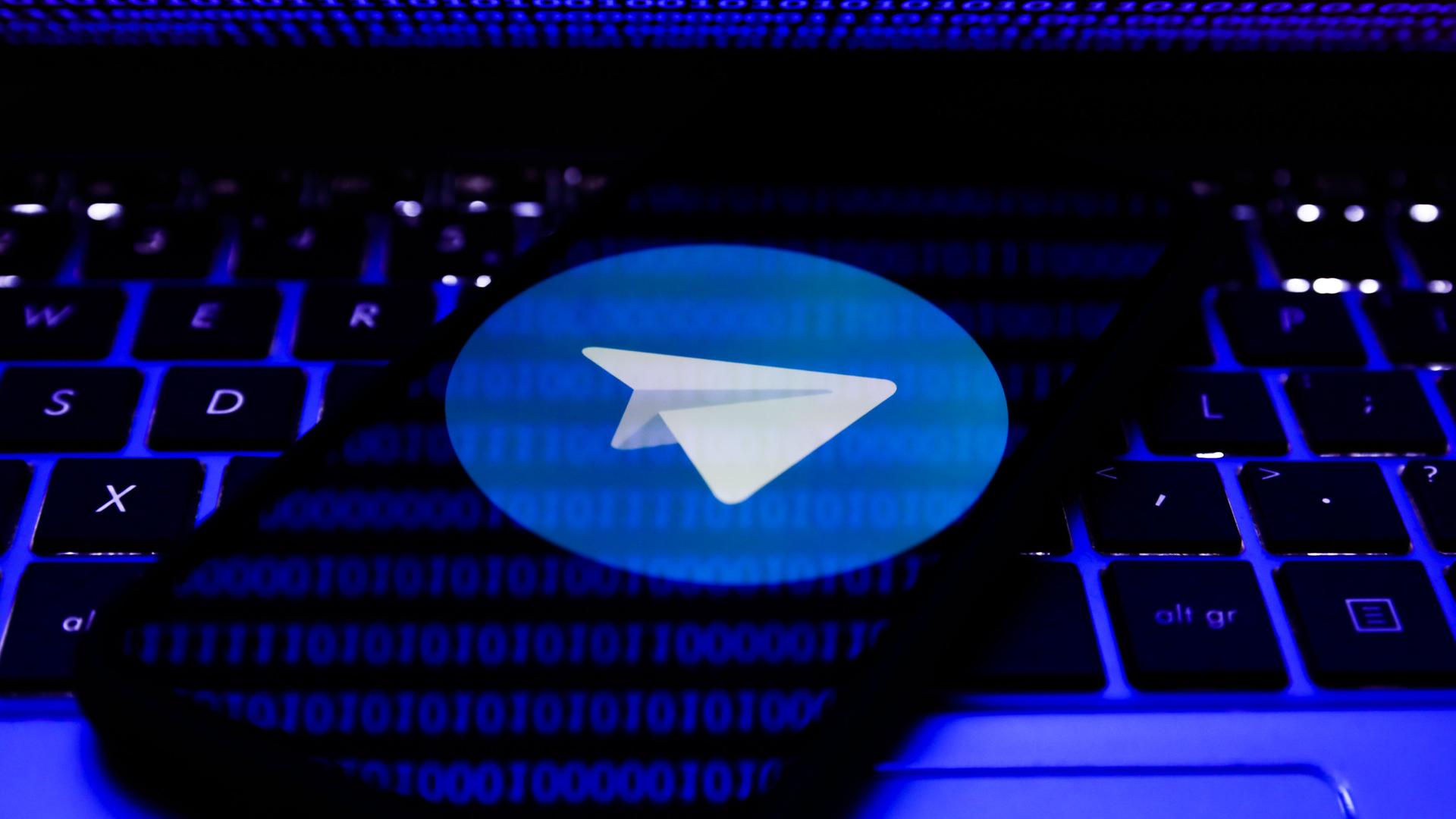Das Logo von Telegram auf einem Handy ist auf der Tastatur eines Labtops zu sehen. Das Logo von Telegram auf einem Handy ist auf der Tastatur eines Labtops zu sehen.