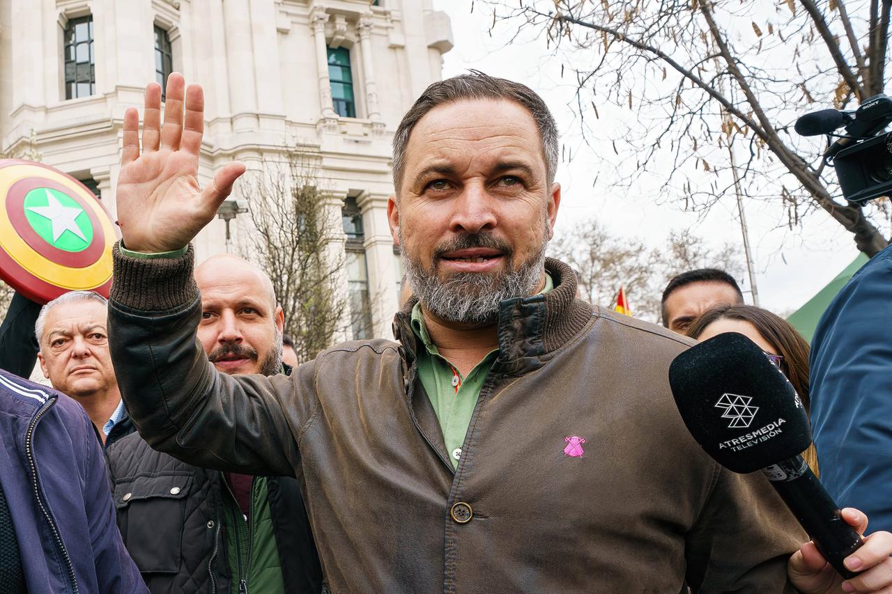 Ein dunkelhaariger Mann mit graumeliertem Bart spricht in ein Mikrofon und hebt dabei die rechte flache Hand. Ein dunkelhaariger Mann mit graumeliertem Bart spricht in ein Mikrofon und hebt dabei die rechte flache Hand.