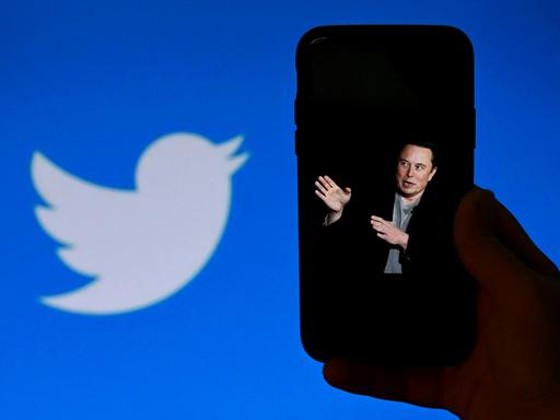 Elon Musk auf dem Display eines Smartphones, daneben das Twitterlogo. Elon Musk auf dem Display eines Smartphones, daneben das Twitterlogo.