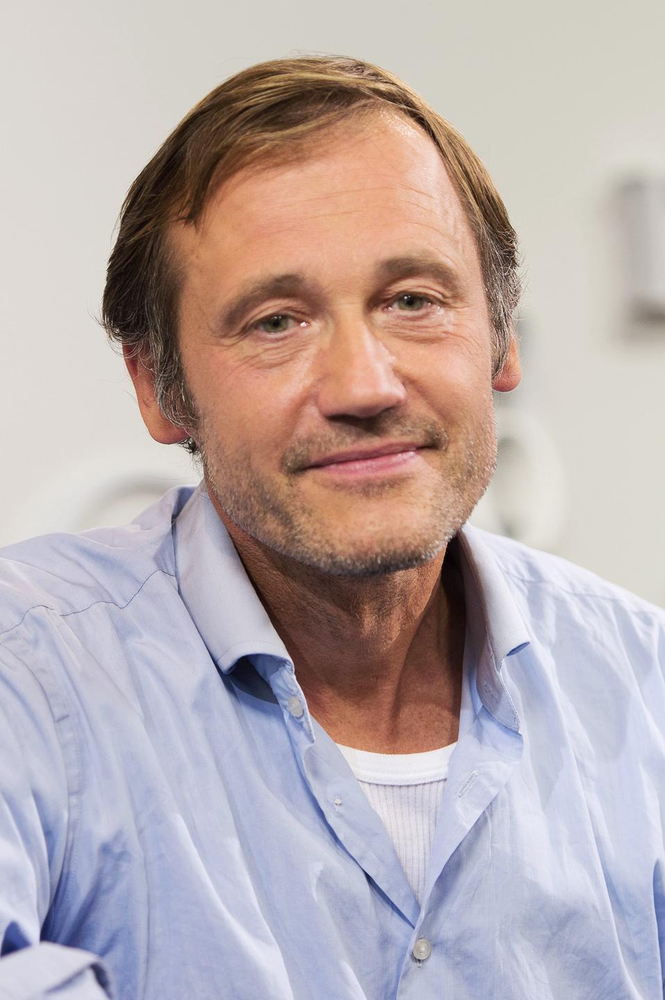 Ein Mann mittleren Alters, schaut freundlich, mit einem nach unten gesenkten Blick. Ein Mann mittleren Alters, schaut freundlich, mit einem nach unten gesenkten Blick.