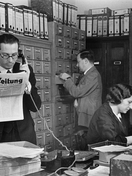 Hans Oppenheimer (im Vordergrund) mit zwei weiteren Mitarbeitenden in der Redaktion der C.V.-Zeitung