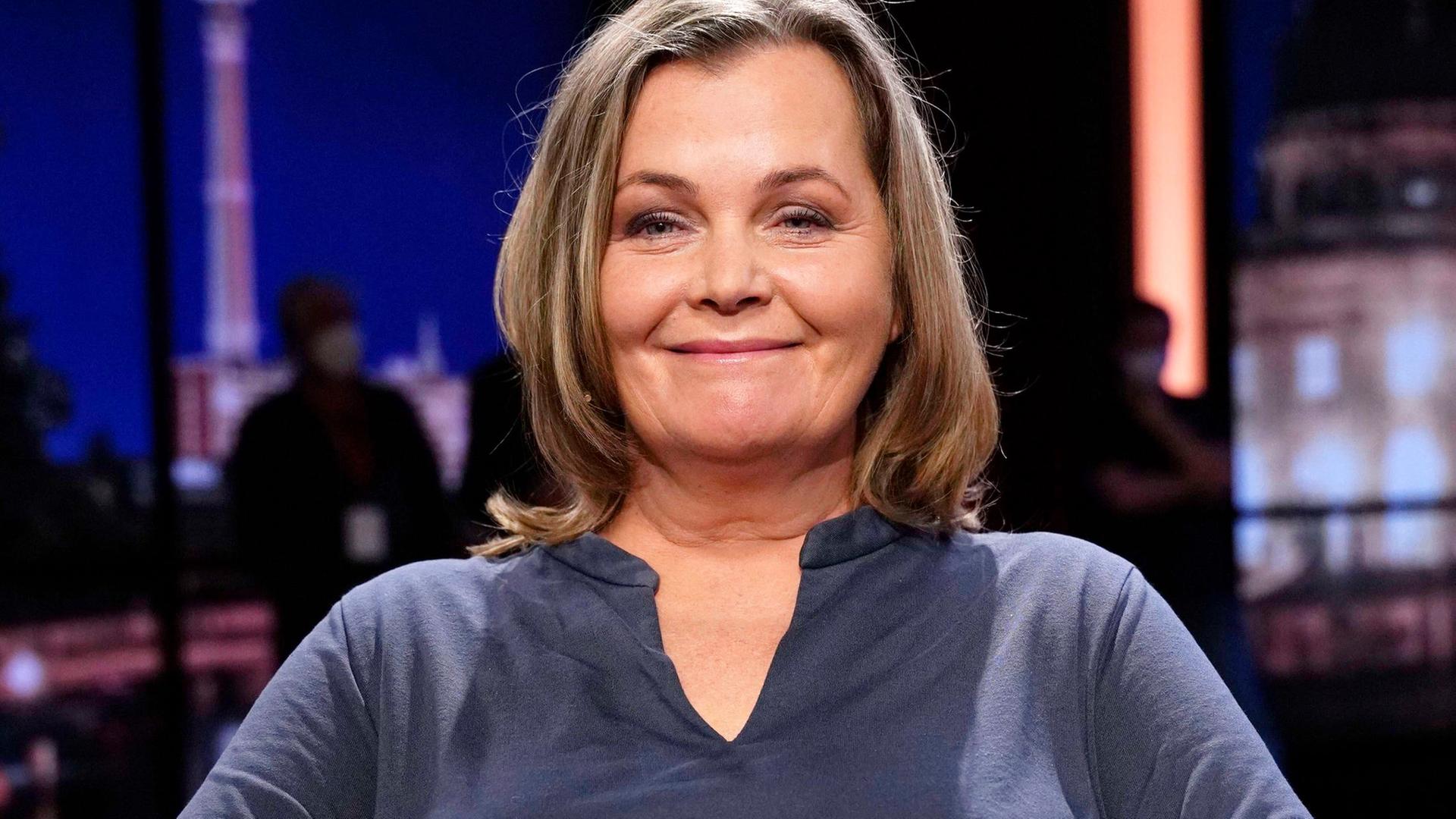 Katja Oskamp sitzt in einem TV-Studio und blickt freundlich in die Kamera Katja Oskamp sitzt in einem TV-Studio und blickt freundlich in die Kamera
