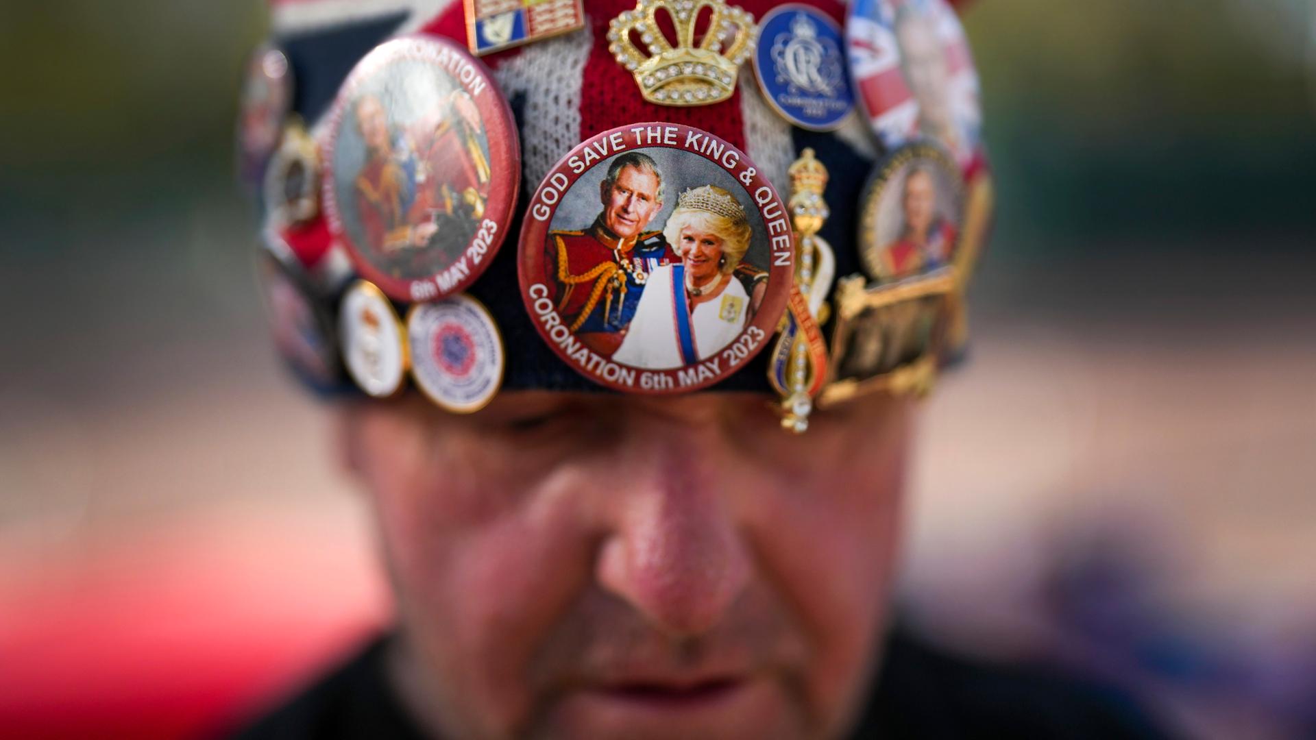 Ein Brite trägt wenige Tage vor der Krönung von King Charles III. eine Mütze, die mit Stickern die britische Monarchie feiert. Ein Brite trägt wenige Tage vor der Krönung von King Charles III. eine Mütze, die mit Stickern die britische Monarchie feiert.
