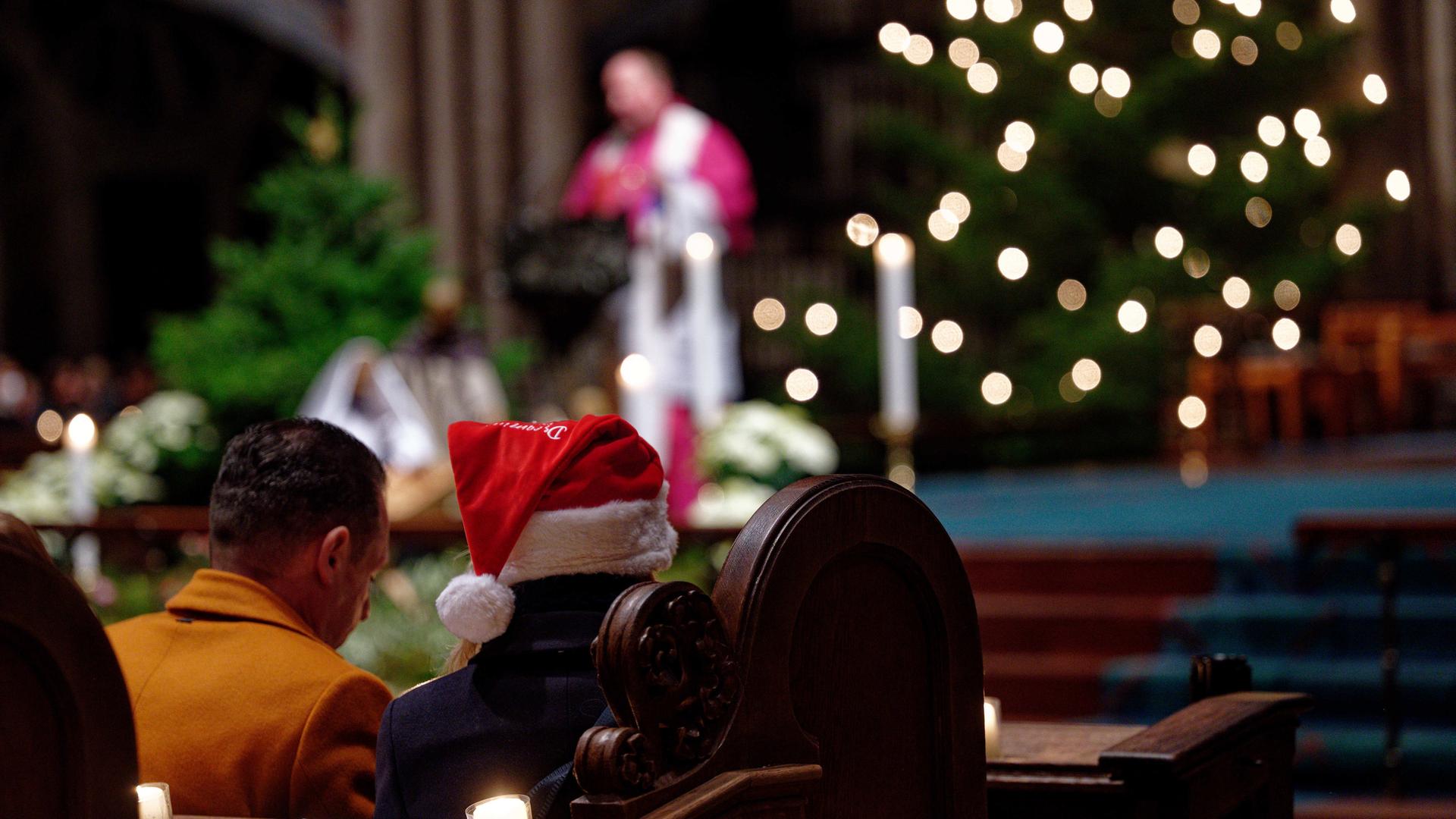 Stadtdechant Robert Kleine leitet die Christvesper im Kölner Dom am Heiligen Abend, Besucher mit Weihnachtsmütze Stadtdechant Robert Kleine leitet die Christvesper im Kölner Dom am Heiligen Abend, Besucher mit Weihnachtsmütze