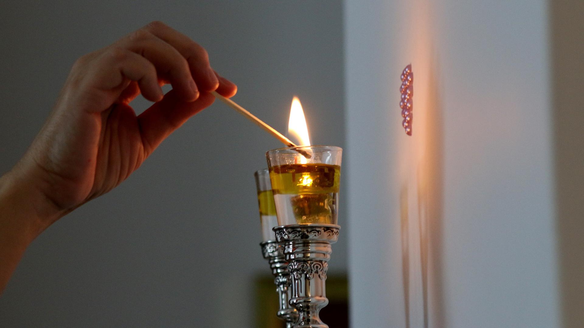 Eine Frau zündet Shabbat-Kerzen an. Eine Frau zündet Shabbat-Kerzen an.
