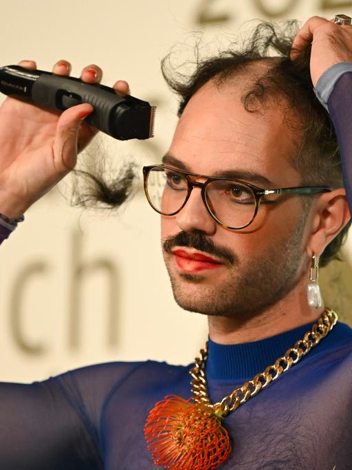 Kim de l'Horizon rasiert sich nach der Auszeichnung mit dem Deutschen Buchpreises 2022 im Frankfurter Römer die Haare ab. 