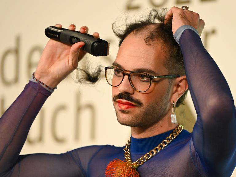 Kim de l'Horizon rasiert sich nach der Auszeichnung mit dem Deutschen Buchpreises 2022 im Frankfurter Römer die Haare ab. 
