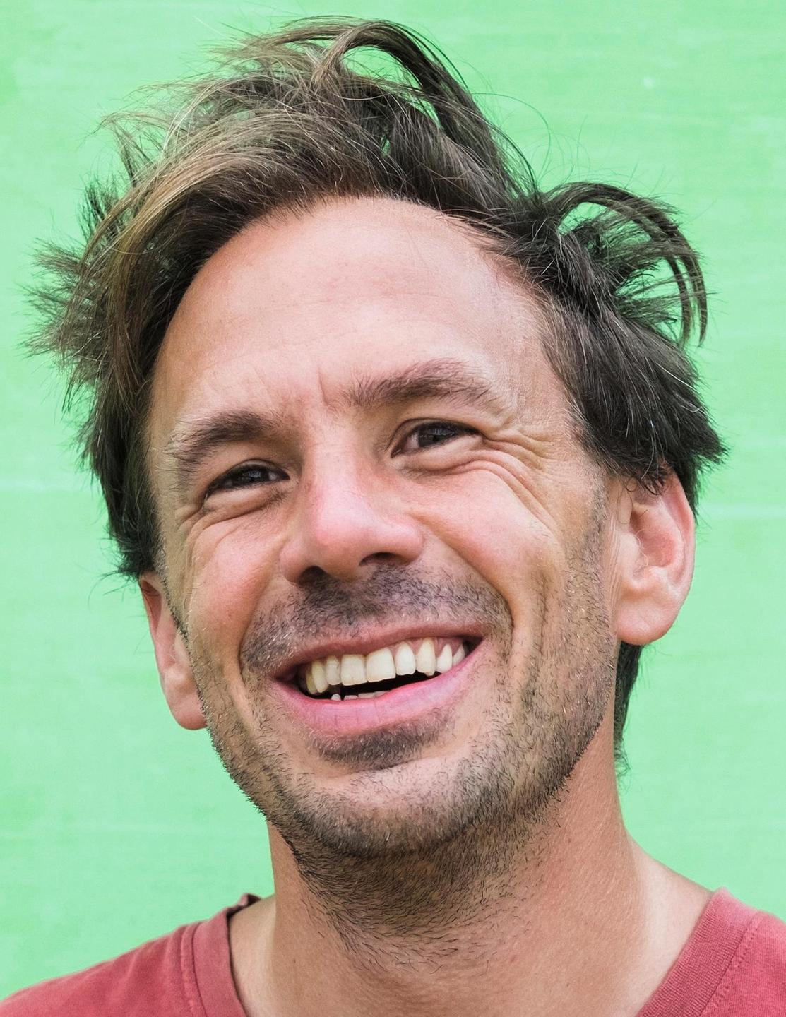 Porträtaufnahme des Schriftstellers Alexander Behr, wie er lacht.