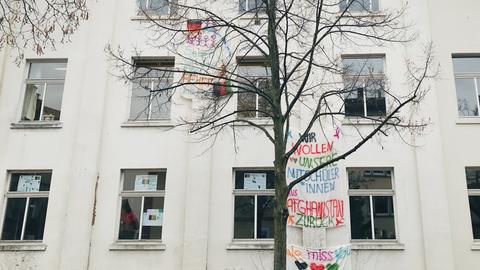 An der Hostatoschule in Frankfurt hängen Bettlaken an der Fassade. Auf einem steht "Wir wollen unsere Mitschüler aus Afghanistan zurück".