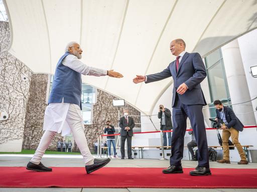 Deutsch-indische Regierungskonsultationen: Bundeskanzler Olaf Scholz begrüßt Narendra Modi, Premierminister von Indien. Die beiden Männer gehen aufeinander mit ausgestreckter Hand zu.