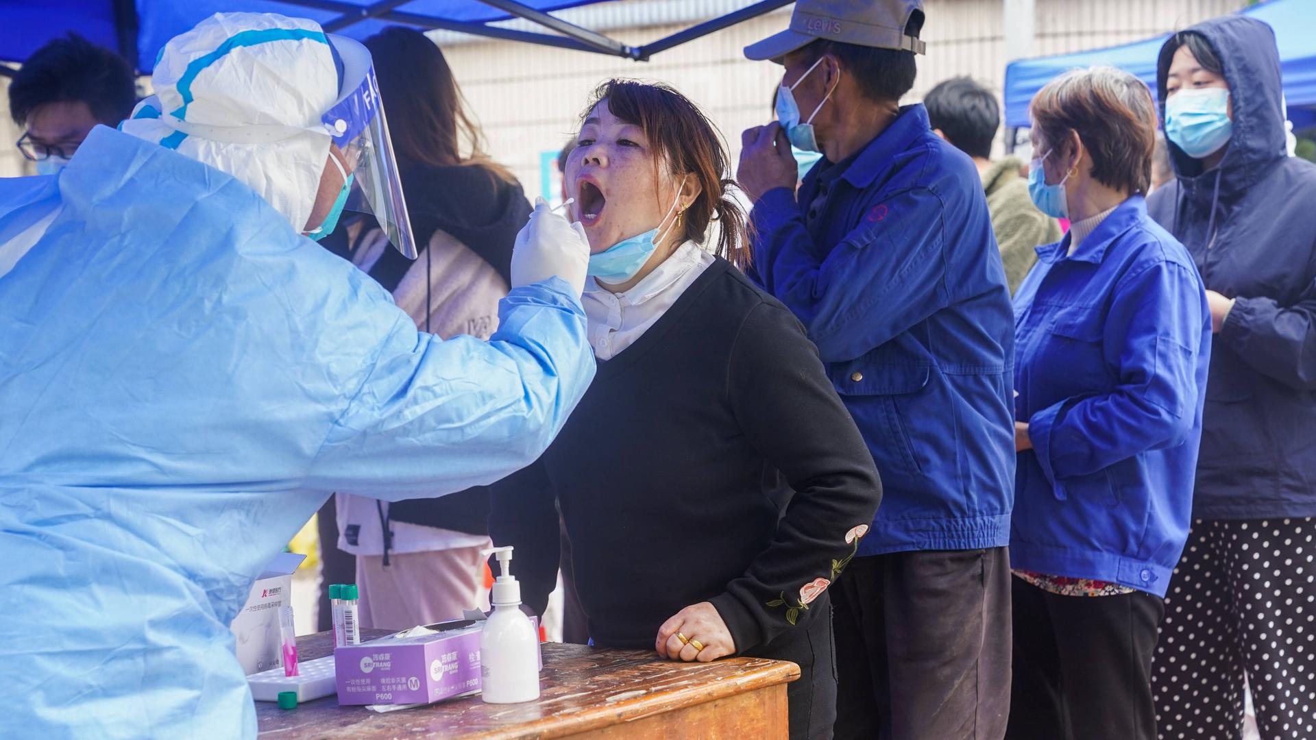 Menschen stehen in Shanghai in einer Schlange, um einen Corona-Test zu machen. Menschen stehen in Shanghai in einer Schlange, um einen Corona-Test zu machen.
