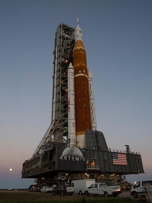 NASA Space Launch System Rakete mit dem Rollout des Orion-Raumfahrzeugs vor Abendhimmel.