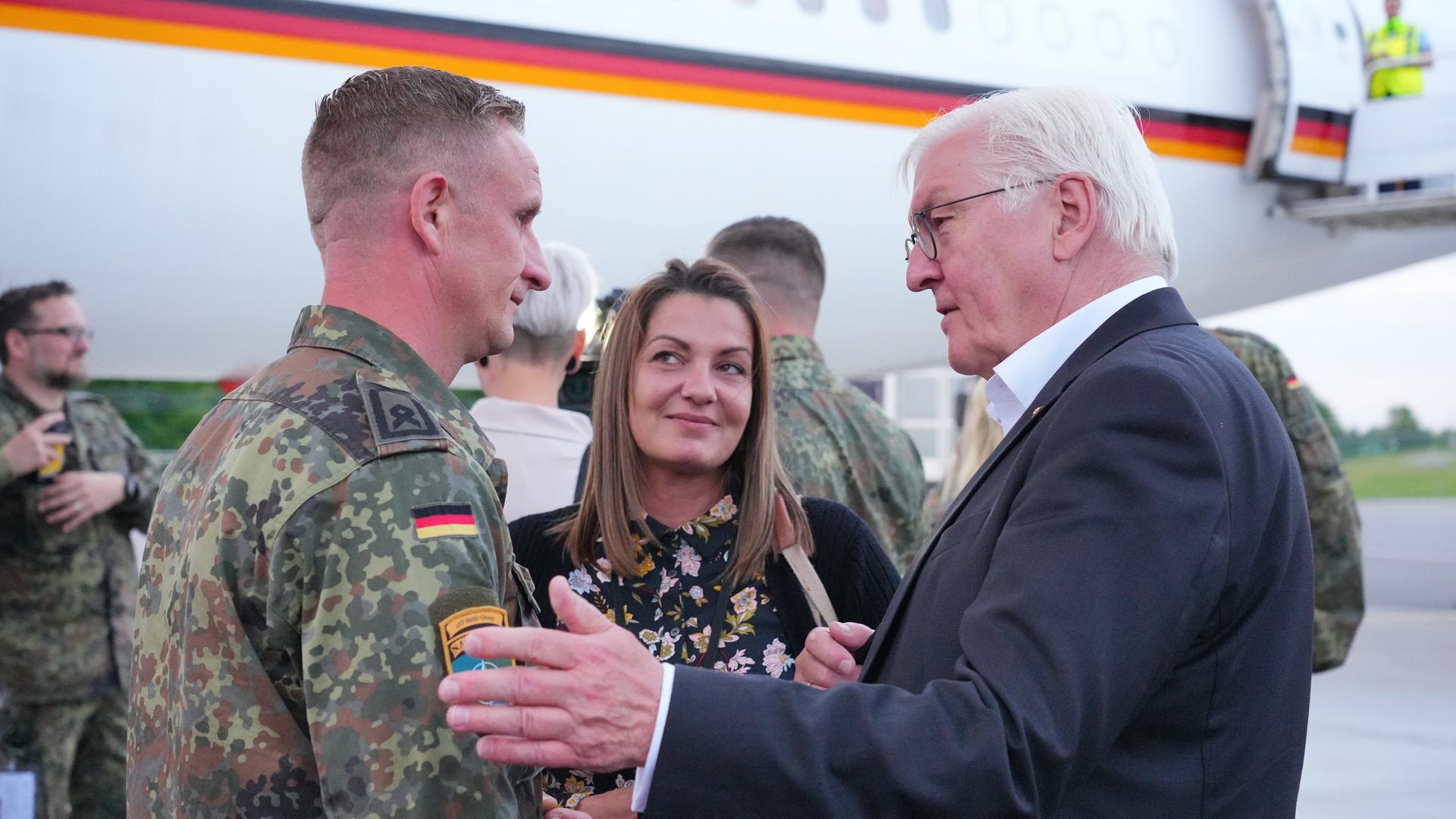 Yvonne Haase und ihr Ehemann Thomas (l.) unterhalten sich auf dem Flughafen von Vilnius mit Bundespräsident Frank-Walter Steinmeier. Yvonne Haase gehört zu den zwölf Angehörigen in Litauen stationierter deutscher Soldaten, die von Bundespräsident Steinmeier zu einer zweitägigen Reise ins Baltikum eingeladen wurden.