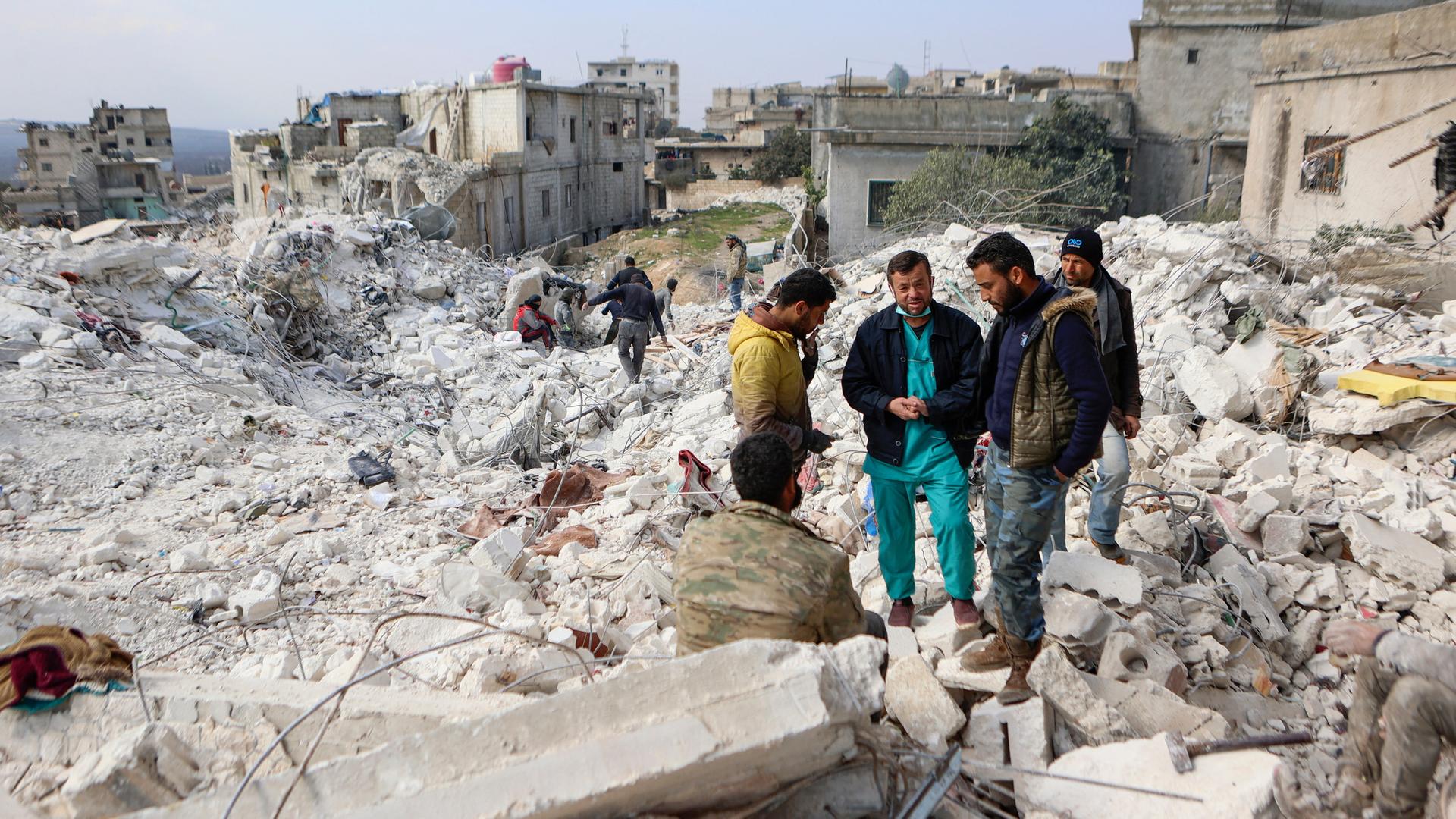 Menschen stehen auf den Trümmern von einem Haus in dem Erd-Beben-Gebiet in Syrien. Menschen stehen auf den Trümmern von einem Haus in dem Erd-Beben-Gebiet in Syrien.
