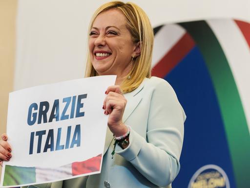 Giorgia Meloni hält Plakat mit "Grazie Italia" hoch