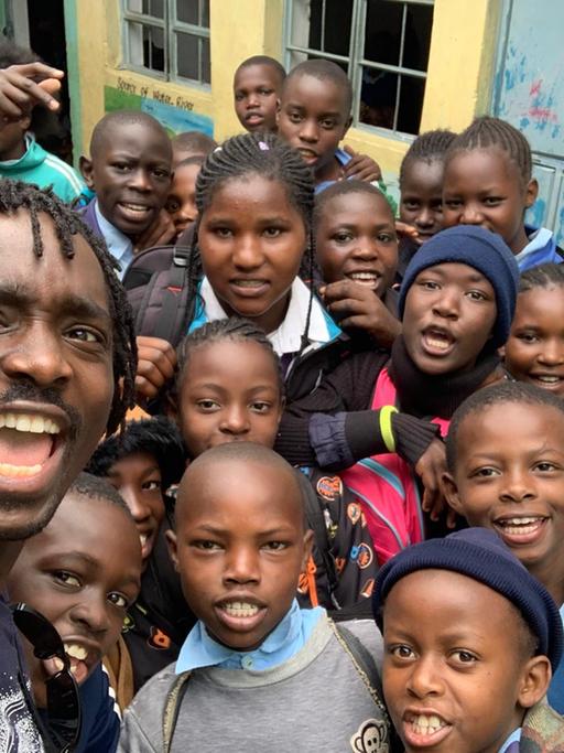 Kevin Ochieng Odour (links) mit Kindern im Slum Kibera in Nairobi. Dort wuchs der Fußballspieler auf.
