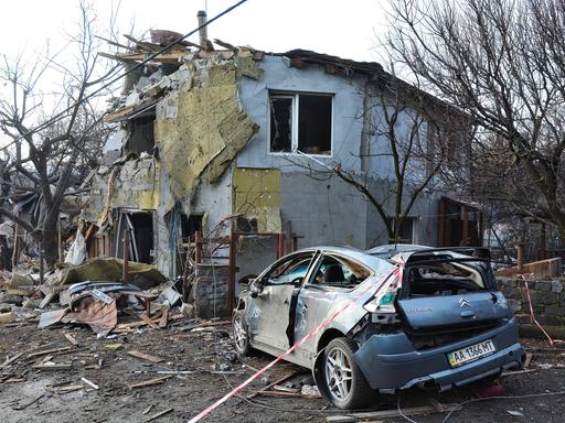 Ein zerstörtes Wohngebäude und ein zerstörtes Auto in Kiew nach einem russischen Raketenangriff