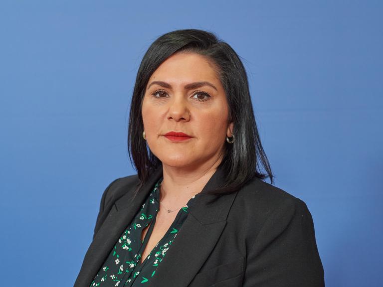 Aktivistin Mariam Claren. Eine Frau mit langen dunklen Haaren schaut in die Kamera.